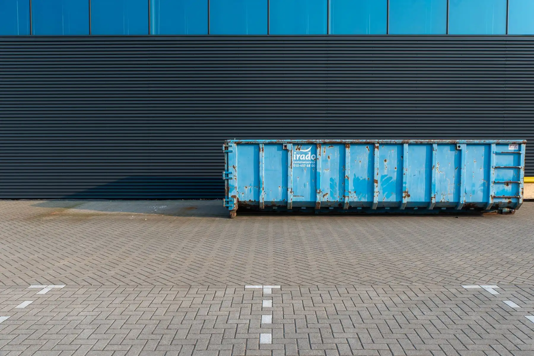 Debris container placed beside a building